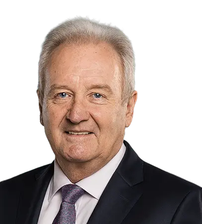 Professional portrait of an elderly businessman in a suit and tie, smiling confidently against a transparent background.